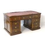 An early 20thC oak pedestal desk comprising a single long central drawer flanked by four short