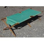 A folding green canvas a wood campaign bed / camping bed CONDITION: Please Note -