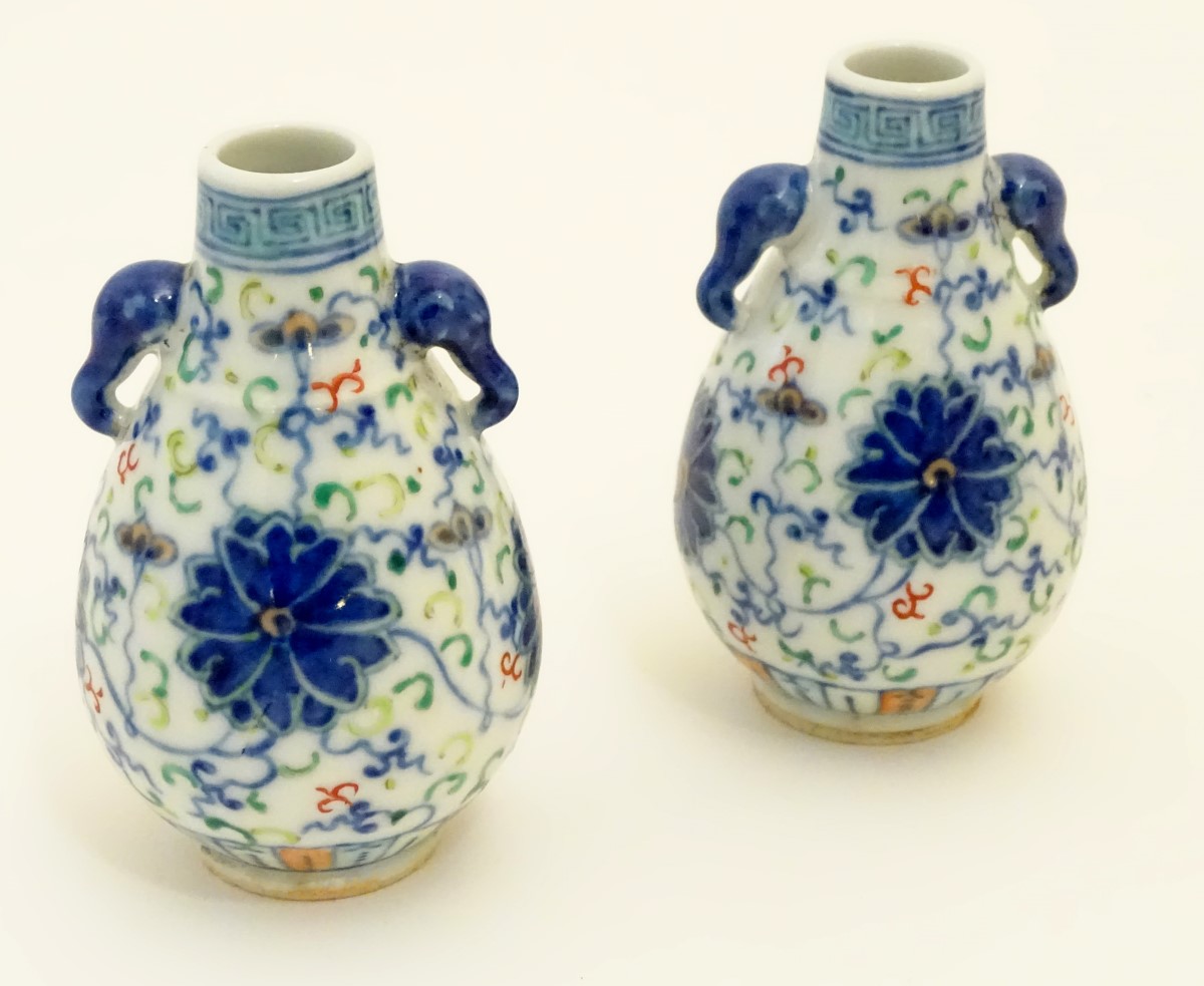 A pair of Chinese miniature doucai baluster vases, decorated with flowers,