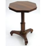 A 19thC octagonal occasional table with a canted pedestal and standing on a triform base above ball