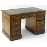 An early / mid 20thC mahogany double pedestal desk with a single long drawer flanked by two banks