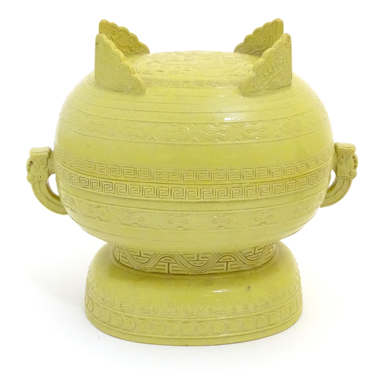 A Chinese yellow ground lidded pot raised on a foot,