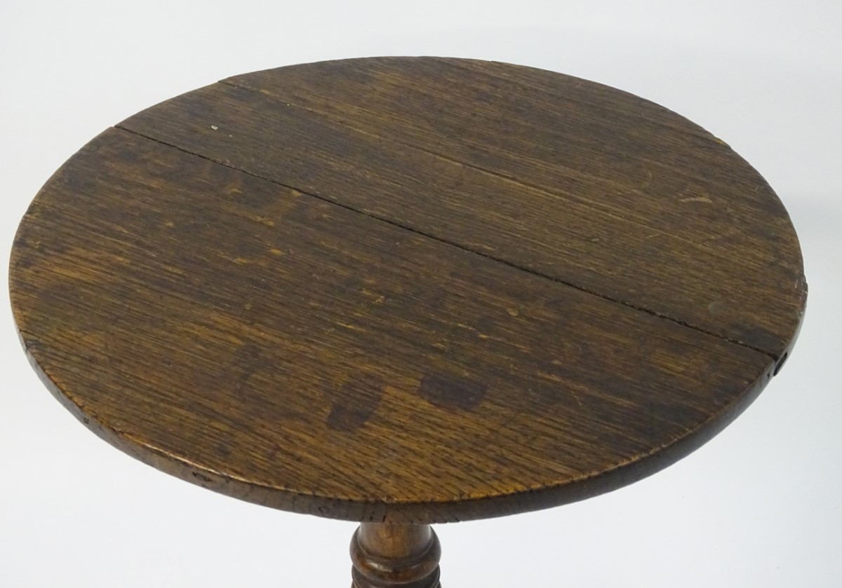 A late 18thC oak tripod table with a circular table top above a turned stem and standing on three - Image 3 of 7