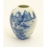 A small Chinese blue and white vase, decorated with a landscape to include mountains, bridges,