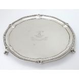 A silver visiting card tray with beaded rim and engraved armorial and motto to centre.