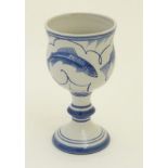 A Laurence McGowan British studio pottery goblet with blue hand painted fish decoration.