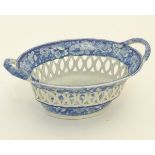 A blue and white twin handled chestnut basket with a reticulated body and a floral border,