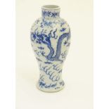 A Chinese blue and white vase with stylised dragon and cloud decoration and floral borders.