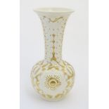 A large cream Burmantofts Faience vase with an elongated neck and a flared rim,