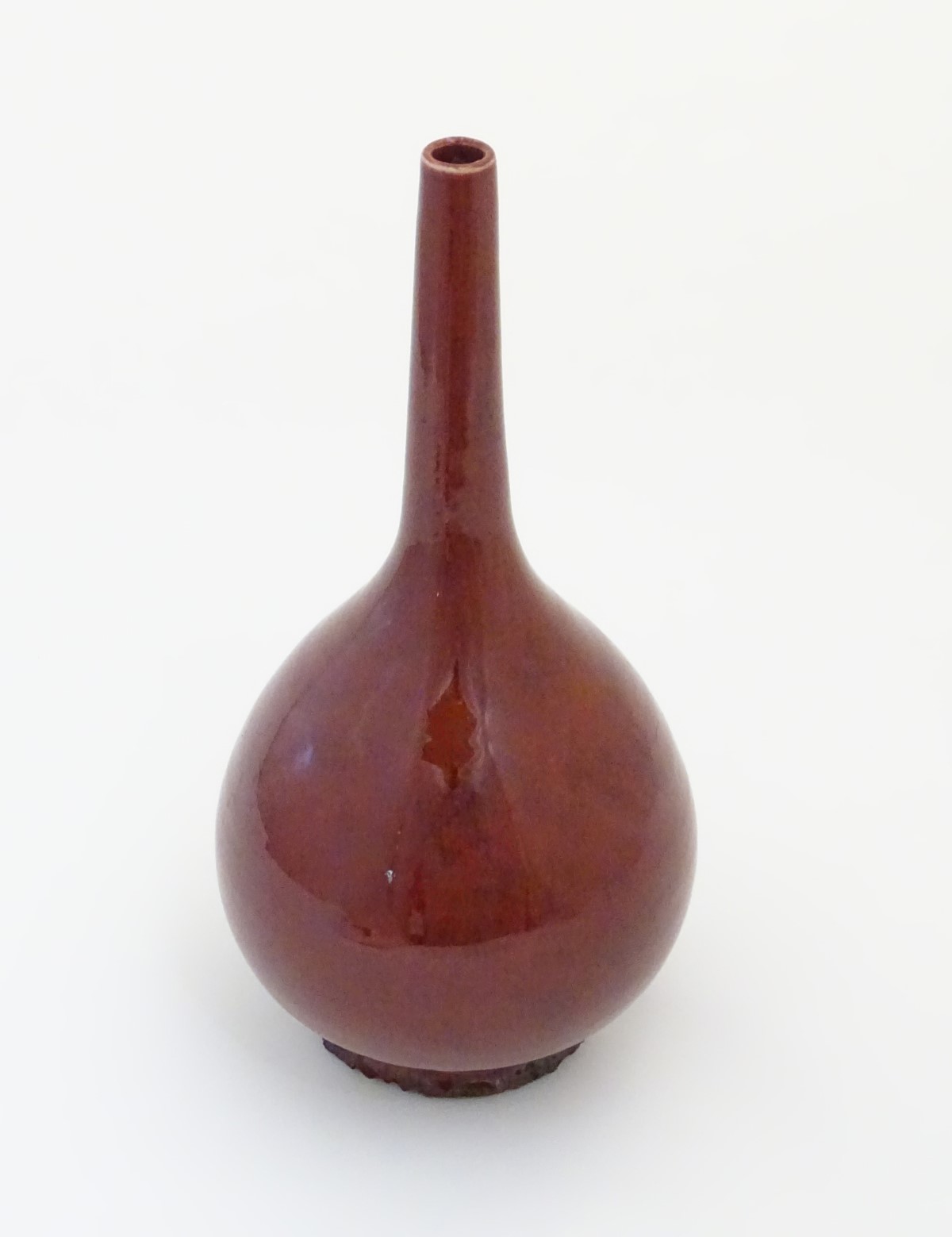A Chinese pear-shaped vase with a slender, elongated neck with a sang de boeuf glaze. Approx.