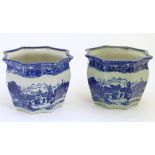 A pair of Masons style blue and white octagonal jardinieres depicting an urban scene with buildings,