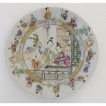 A Chinese plate decorated with figures in an interior playing a guqin.