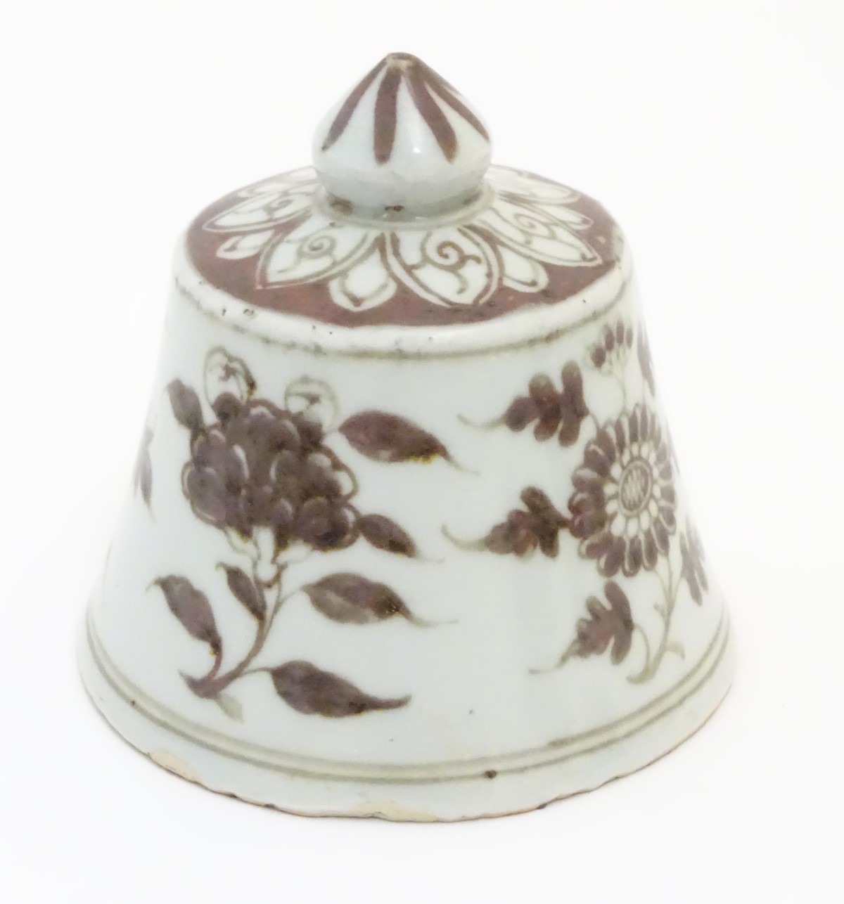 A Chinese brown and white bell-shaped cover with floral decoration. 4" high.