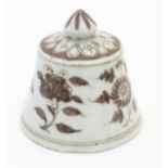 A Chinese brown and white bell-shaped cover with floral decoration. 4" high.