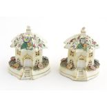 A pair of Staffordshire pottery pastille burners in the form of cottages, decorated with flowers.