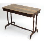 A late 19thC rosewood side table with a moulded top above turned supports united by a matching