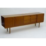 Vintage Retro: a long teak sideboard, in the Nathan form having a pair of cupboard doors to left,