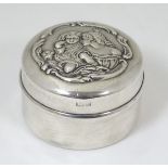 A silver pot with embossed decoration to lid depicting mother and child.