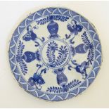 A Chinese blue and white dish decorated with four baluster vases,