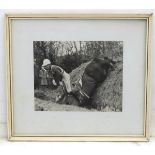 Racing: A framed mid 20thC black and white horse racing photograph of a faller at a ditch during a