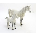 Two Beswick horse figurines, a dapple-grey mare and foal, stamped Beswick England under.