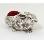 A novelty silver plate pin cushion formed as a rabbit.