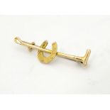 A 9ct gold bar brooch / stock pin with riding crop and horseshoe decoration.