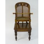 A Victorian mahogany child's chair with a curved backrest having a caned back and seat,