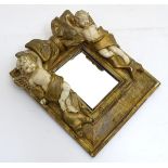 A contemporary wall mirror with gilt and cream decoration of cherubs flanking a bow,