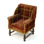 A late 19thC / early 20thC childs wingback armchair raised on four tapering turned supports.