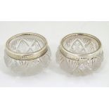 A pair of cut glass salts with silver rims hallmarked London 1916 maker R.P.