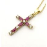 A 9ct gold cross formed pendant set with red and white stones 1" long with an 18" long 9ct gold