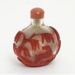 A Chinese overlaid glass snuff bottle with image in red of a horse under a tree,