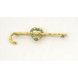 A gold bar brooch/ pin formed as a walking stick / cane with heart decoration set with seed pearl