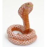 A hand painted Herend porcelain model of a cobra with gilt highlights.