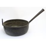 A large 19thC copper cooking pan with a tapering hollow handle and loop carry handle,