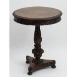 A mid 19thC Anglo-Indian table with a circular carved table top above a tapering stem having a