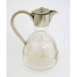 A cut glass claret jug with silver plated mounts and handle.
