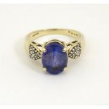 An 18ct gold tanzanite and diamond ring, the central tanzanite approx 4.