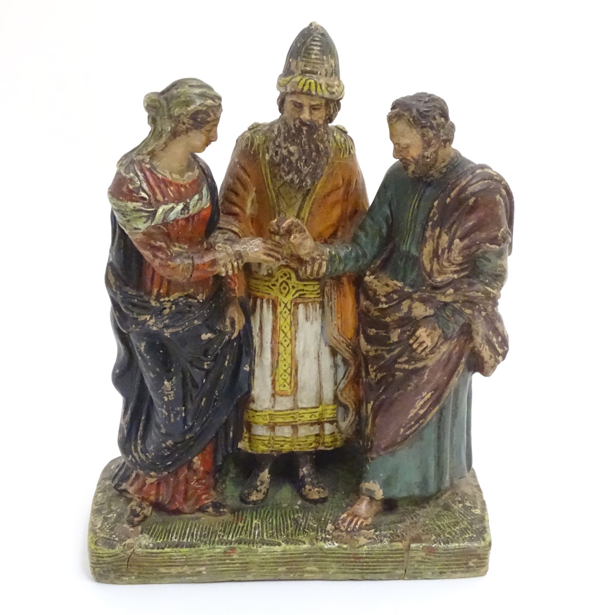 A terracotta figural group of three people on a rectangular base,