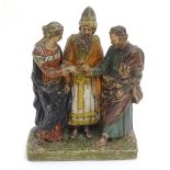 A terracotta figural group of three people on a rectangular base,