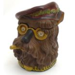 A terracotta polychromed novelty jar modelled as a dog wearing a Tam-o-Shanter and spectacles,