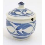 A Derek Emms studio pottery lidded preserve pot, with blue and white stylised foliage decoration.