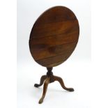 A late 18thC tripod occasional table with a cherry wood table top above a tapering turned stem and
