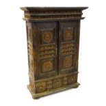 A 19thC Middle Eastern cabinet with a moulded cornice above finial colonnades and panelled doors