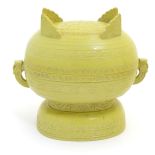 A Chinese yellow ground lidded pot raised on a foot,