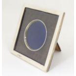 A silver photograph frame of squared form with central circular aperture The whole 6 1/2" x 6 1/2"