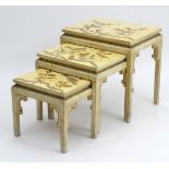 An early 20thC nest of three tables oriental tables with decoration to the tops and brackets to the