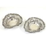 A pair of silver heart shaped bon bon dishes with embossed decoration.