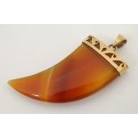 A 14ct gold mounted pendant set with carnelian shaped as a tigers claw.